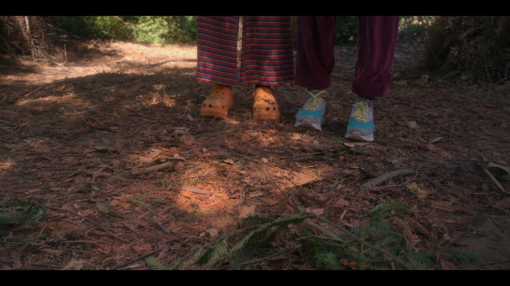 Crocs Orange Platform Heeled Mules of Zoe Colletti as Gia and Reebok Shoes of Lana Condor as Erika in Boo, Bitch S01E01 “Life's a Bitch and Then You Die” (2022) (Image 2)