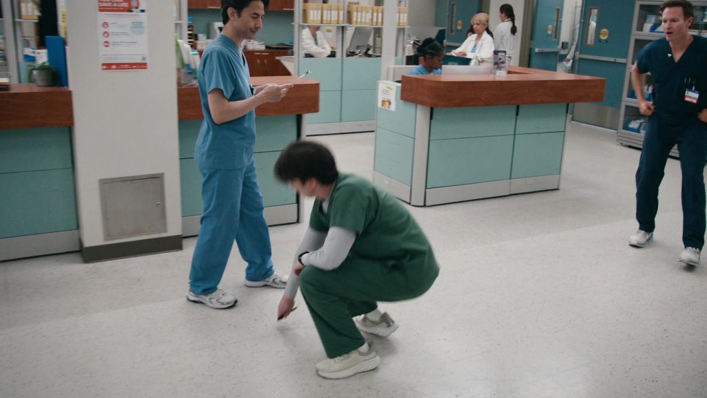 Hoka Arahi 7 running shoe in the Oat Milk -Barley colorway in St Denis Medical S02E03 “Get Me in the Pod, Brother” (2025) (Image 1)
