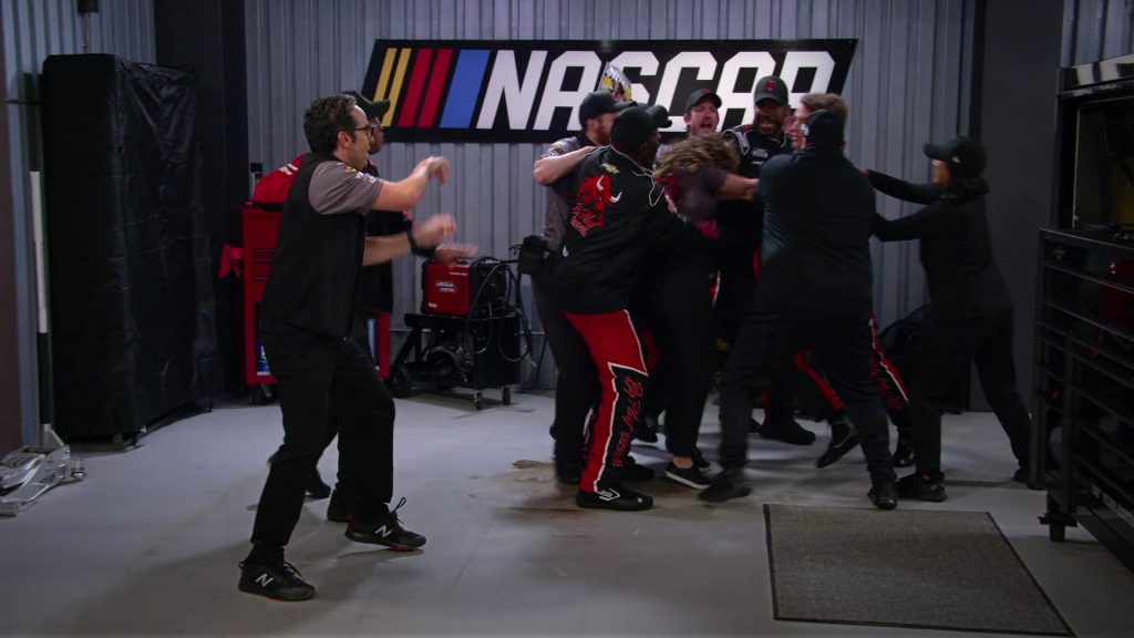 New Balance Men's Sneakers of Dan Ahdoot as Amir and NASCAR Sign in The Crew S01E01 “I Guess That Cake Did Need To Be Refrigerated” (2021) (Image 1)
