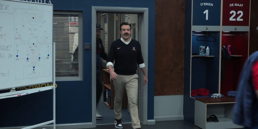 Nike AJ 1 Shoes and Sweater Worn by Jason Sudeikis in Ted Lasso S03E10 “International Break” (2023) (Image 1)