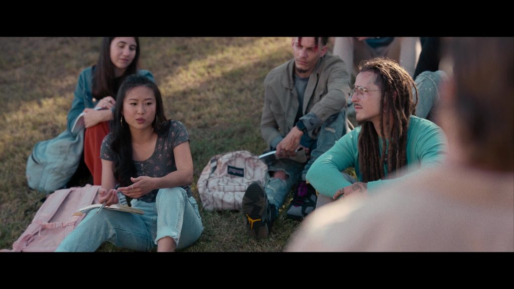 Nike Air Jordan Sneakers and JanSport Backpack in Hit Man (2023) (Image 3)