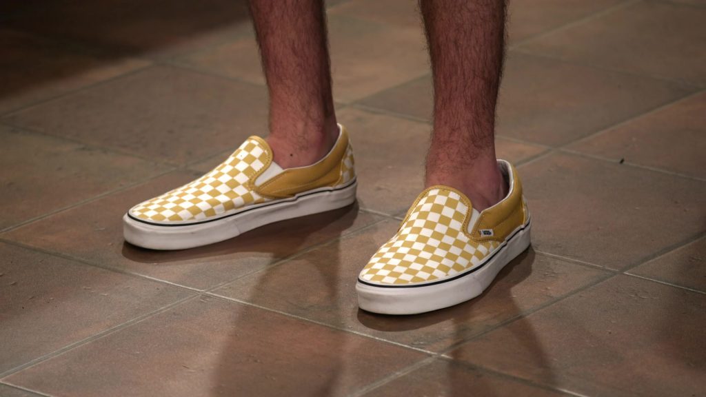Vans Classic Slip On Checkerboard Ochre & White Shoes of Reed Horstmann as Stick in The Expanding Universe of Ashley Garcia S01E12 “Count Me In” (2020) (Image 1)